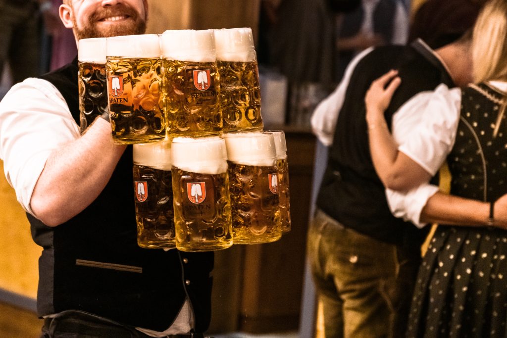 Munich, Germany - September 21, 2019: waiter carrying a lot of beer glasses in beer tent at Octoberfest in Munich